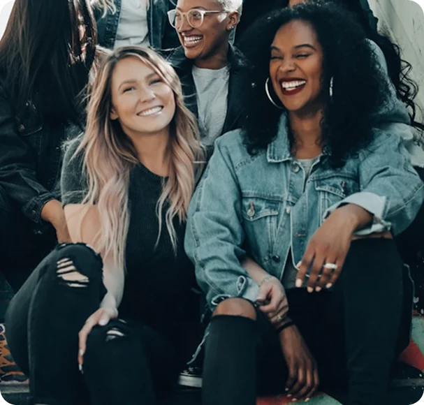 A group of friends sitting together outdoors, laughing